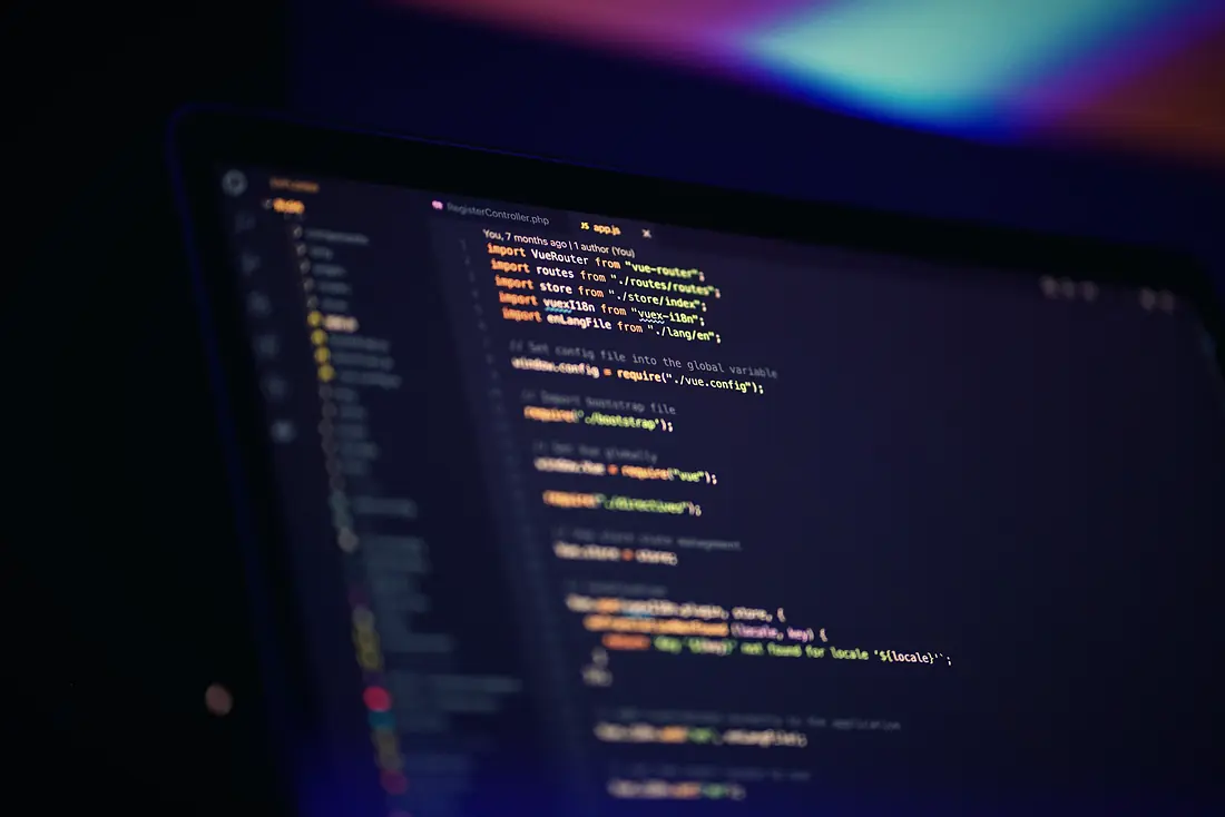 Code on a laptop screen in a dark room